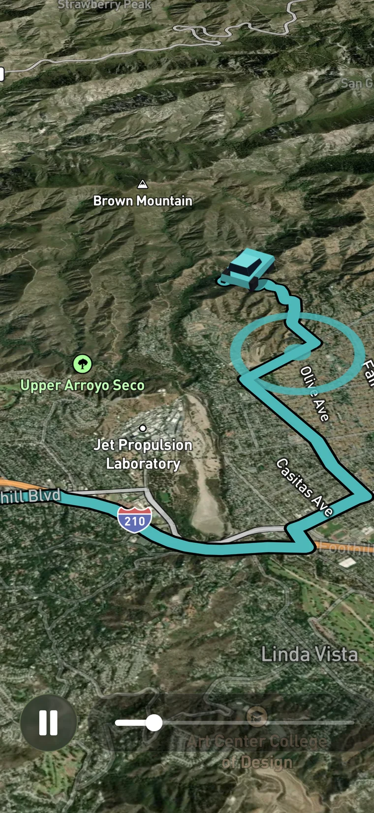 Ride Replay running in the app: a teal route traced over 3D satellite terrain below Brown Mountain, a car model partway along it, named streets either side, and a pause button beside a scrub bar at the bottom.