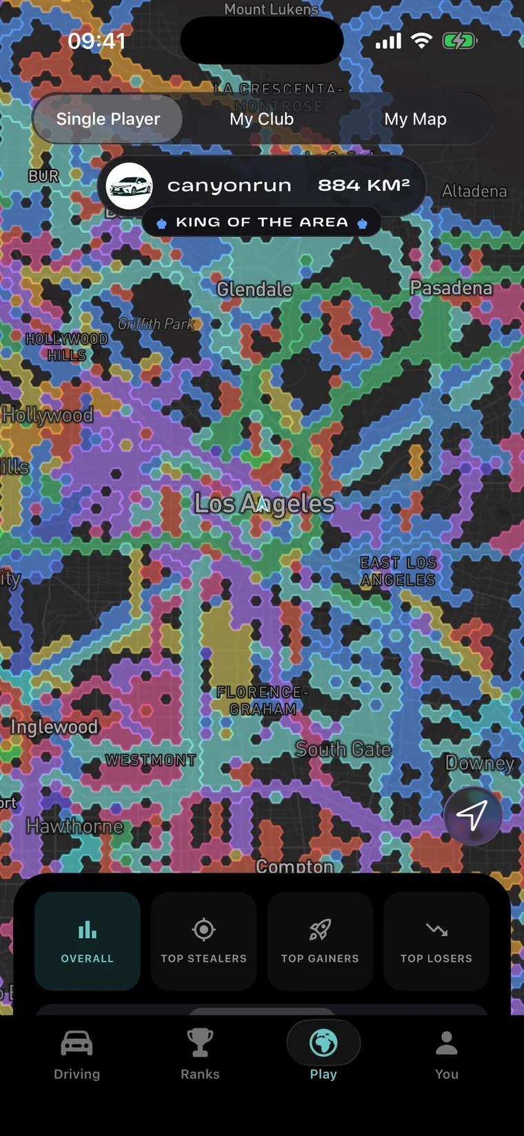 The Play tab in Enroad: the Single Player map over Los Angeles, with the hexagon grid filled in the colours of the drivers holding each cell, a KING OF THE AREA banner over the biggest holder, and the Overall, Top Stealers, Top Gainers and Top Losers boards along the bottom.